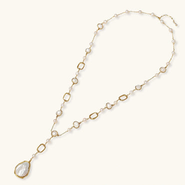 Long gold-plated necklace with alternating freshwater pearls and crystal bezels, featuring a large baroque pearl pendant
