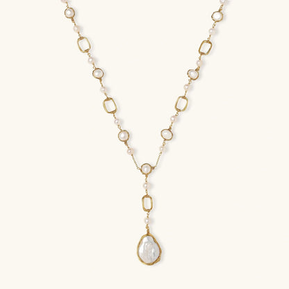 Long gold-plated necklace with alternating freshwater pearls and crystal bezels, featuring a large baroque pearl pendant