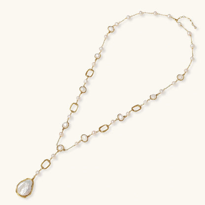 Long gold-plated necklace with alternating freshwater pearls and crystal bezels, featuring a large baroque pearl pendant